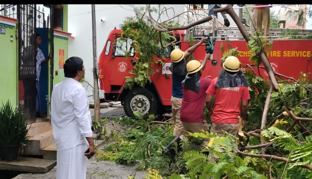பலத்த காற்றால் முறிந்து விழுந்த மரக்கிளைகளை அப்புறப்படுத்தி போக்குவரத்தை சீர் செய்தனர்